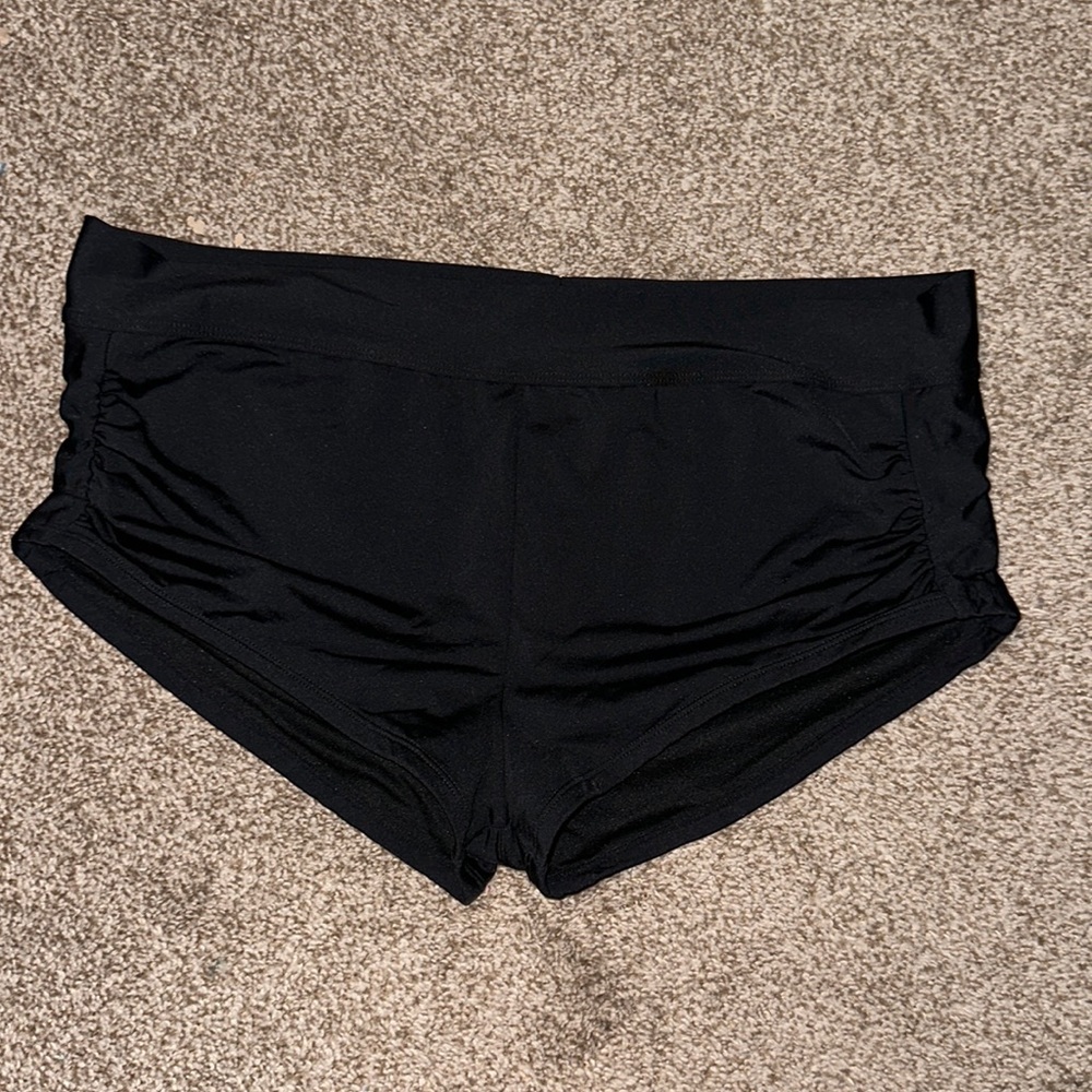Black swim shorts that are cinched on the sides